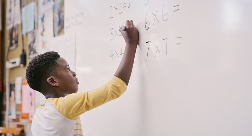 Boy solves math problem in class. pattern problem solving.